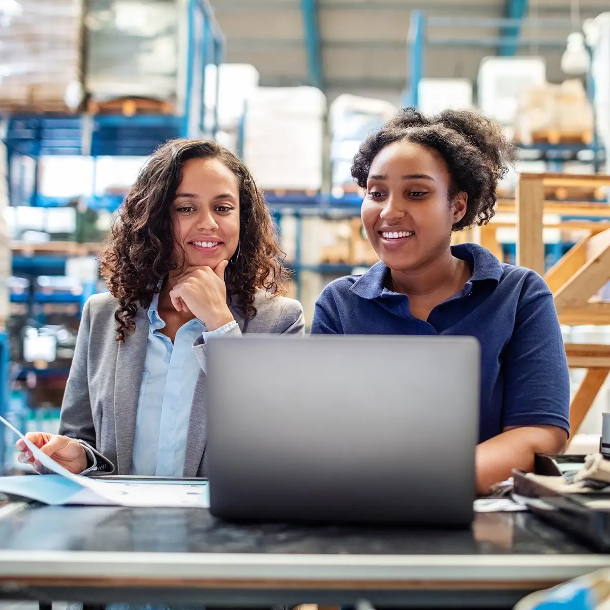 Twee fabrieksarbeiders achter een laptop